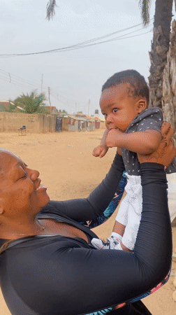 Woman plays with baby outside in Sabon Tasha, Nigeria