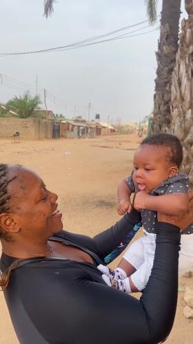Woman plays with baby outside in Sabon Tasha, Nigeria