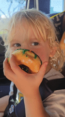 Child enjoys green-iced donut in car seat, Florida Keys