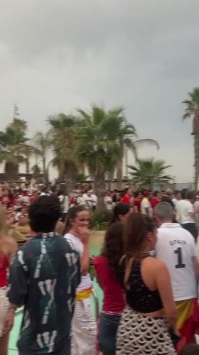 Barcelona crowd gathers for outdoor sports watch party in red and yellow