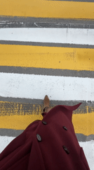 Pedestrian crosses street in burgundy coat in Ufa