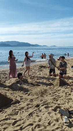 Beach group buries a friend in the sand at Nha Trang