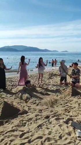 Beach group buries a friend in the sand at Nha Trang