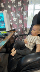 Toddler uses gaming computer at home desk in Russia