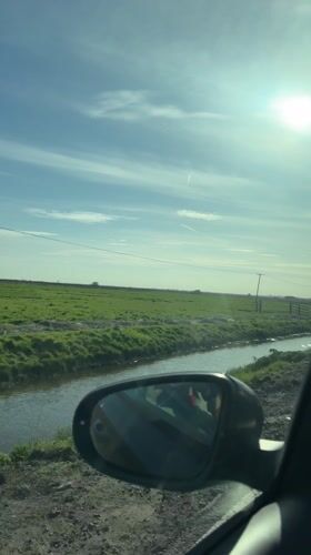 Vehicle travels muddy road near stream in Great Yarmouth