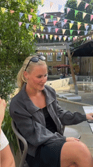 Woman celebrates birthday with cake at outdoor table