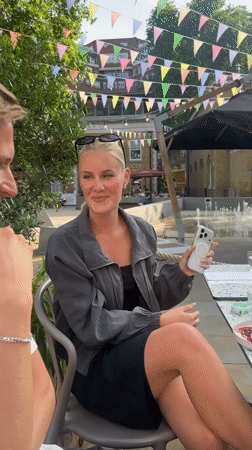 Woman celebrates birthday with cake at outdoor table