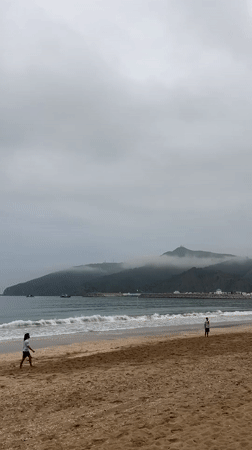 Overcast evening beach life captured in M'Diq, Morocco