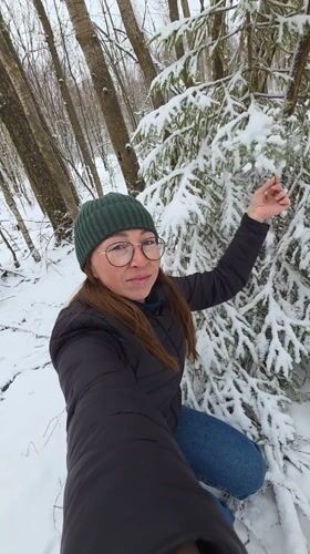 Woman films winter selfies in Russian forest near Kamennyi Kliuch
