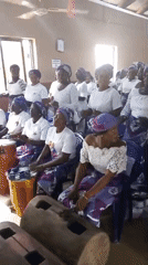 Women's musical group performs in coordinated outfits at community venue