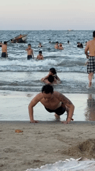 Busy morning on Da Nang's beach — swimming, parasailing, and shoreline activity