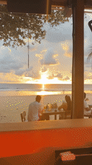 Sunset beach bar vibes with a DJ set underneath.