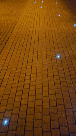 Blue lights illuminate brick pathway in Lutherstadt Eisleben at night