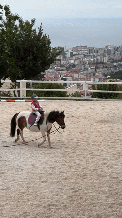 Young rider practices on pony in Montenegro arena