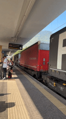 Morning platforms at Trento station, trains and passengers in motion
