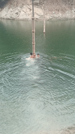 Young swimmers climb concrete pillars in Tinaquillo lake