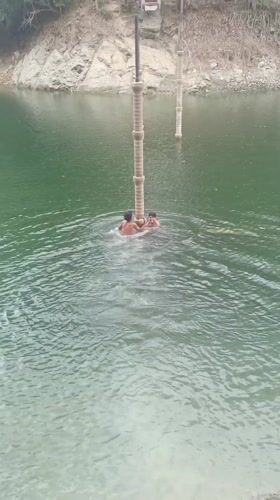 Young swimmers climb concrete pillars in Tinaquillo lake
