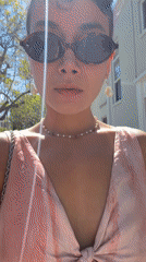 Woman in purple hair, tie-dye dress walks in sunny LA