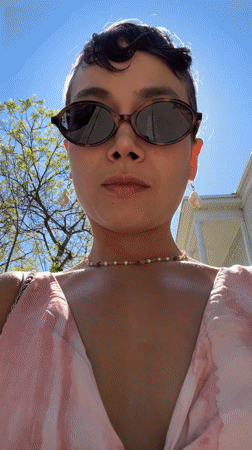 Woman in purple hair, tie-dye dress walks in sunny LA