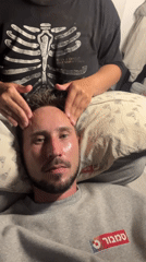 Woman applies skincare product to man's face indoors