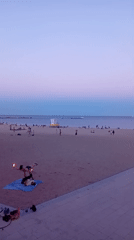 Acro-yoga and fire spinning on a Barcelona beach at dusk
