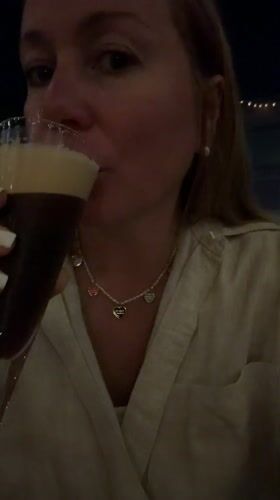Woman enjoys dark beverage at Cape Town bar evening