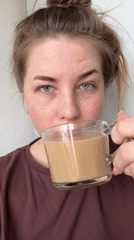 Woman drinks from glass mug in Chaikovsky, Russia
