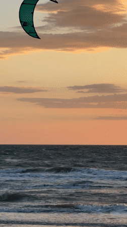 Kitesurfer rides waves at sunset near Shcholkino, Ukraine