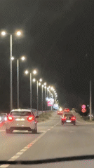 Evening traffic flows on lit Podgorica street
