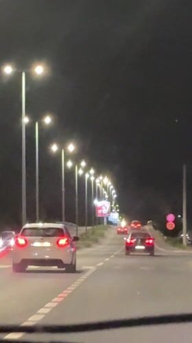 Evening traffic flows on lit Podgorica street