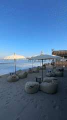 Beachside lounge area with beanbag chairs and tasseled umbrellas