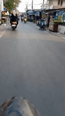 Riding through a busy shopfront street in Banjarmasin