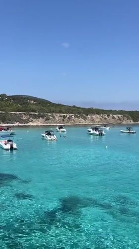 Boats anchored in clear turquoise water off Neo Chorio, Cyprus