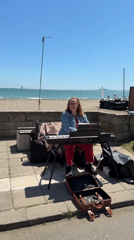 Beach visitors enjoy music, volleyball under clear skies