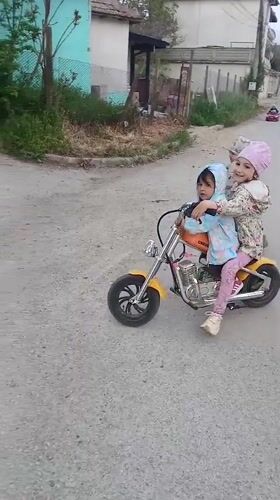 Children ride toy motorcycles on Bulgarian village street