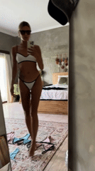 Woman takes bikini selfie near art display in Kuta