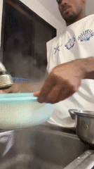 Man cooks spaghetti and eggs breakfast in Porlamar kitchen