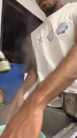 Man cooks spaghetti and eggs breakfast in Porlamar kitchen