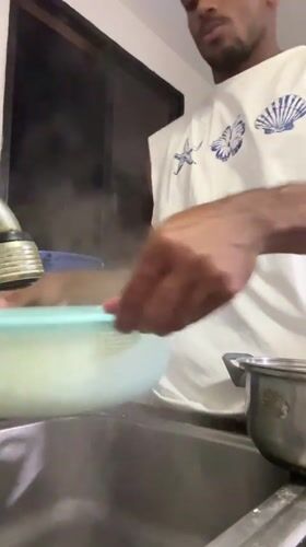 Man cooks spaghetti and eggs breakfast in Porlamar kitchen