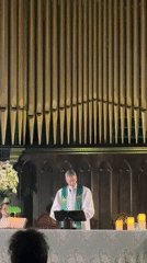 Church service underway in São Paulo, pipe organ glowing behind the lectern