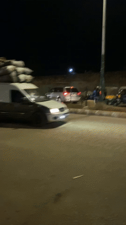 Nighttime street market bustles with vendors and shoppers in Bukuru