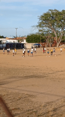 Young people play soccer on dusty field in Ciudad Guayana