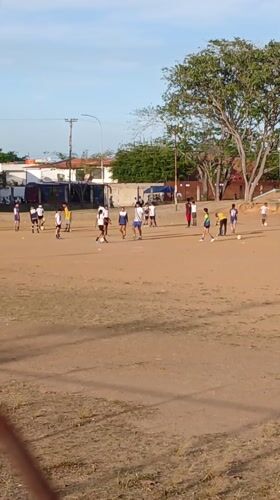 Young people play soccer on dusty field in Ciudad Guayana
