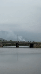 Dragon incense burner and smoky bridge near a riverside temple