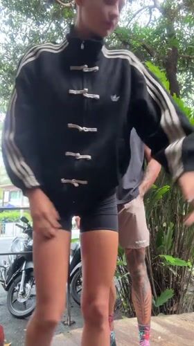 Couple poses on platform in Thailand alongside cash bundles