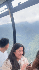Cable car ride over misty Hoàng Liên mountains, phones out