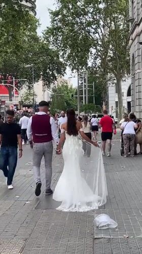 Wedding couple strolls through Barcelona streets mid-morning
