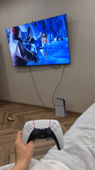 Person enjoys evening PlayStation gaming session with Bengal cat companion