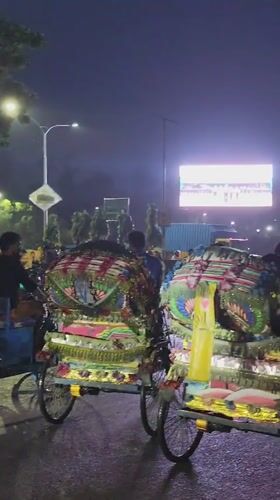 Decorated rickshaws on a Dhaka street at night