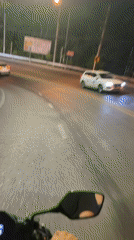 Motorcycle rider travels Patong road amid traffic